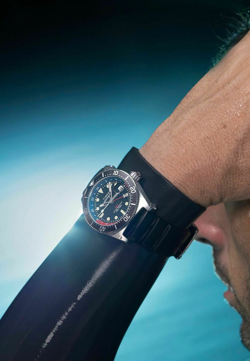 Duikhorloge met een zwarte wijzerplaat, een kast van roestvrij staal en een zwarte siliconen band. Voorzien van lichtgevende markers en een draaibare lunette.