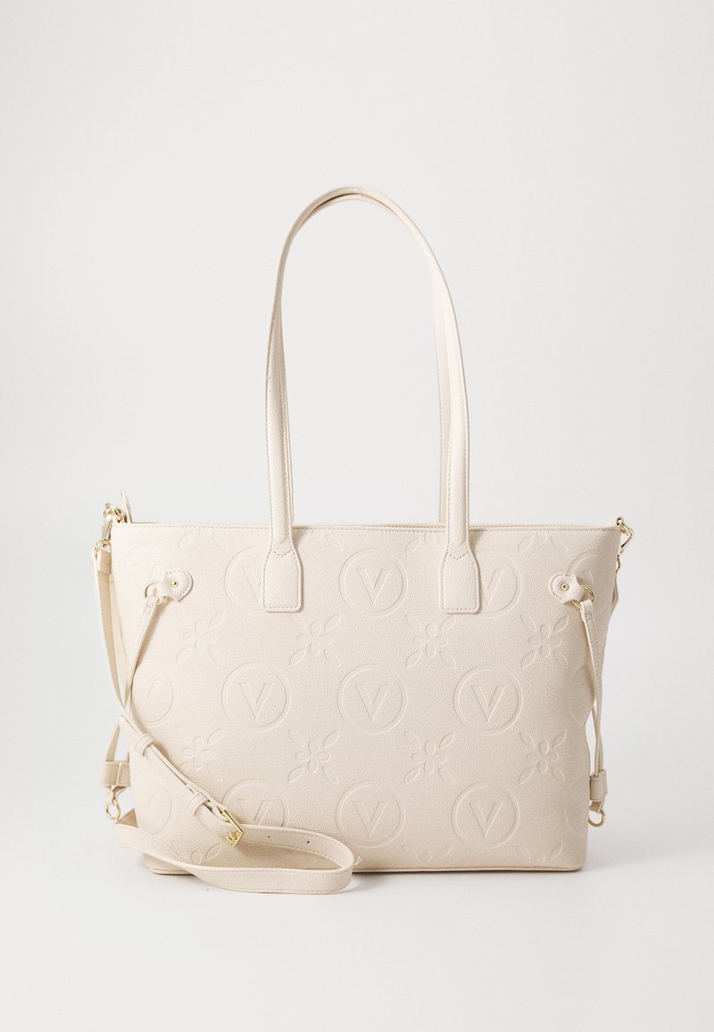 Sac fourre-tout beige avec un motif floral et logo embossé. Présente deux longues poignées et une bandoulière amovible. Matière texturée.
