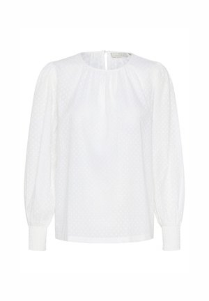 Bijela bluzica s točkicama, okruglim izrezom i elastičnim manžetama. Ima dugačke puf rukave i otvaranje u obliku ključanice na leđima.