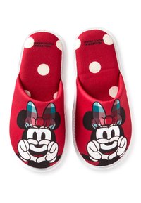 Czerwone kapcie z tkaniny z białymi kropkami i grafiką postaci z kratkowaną kokardą. Kapcie mają białą lamówkę.