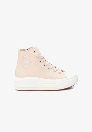 Zapatillas altas de cuero beige suave con una puntera y suela de goma blanca. Presentan cordones tonales y un logo circular en el costado.