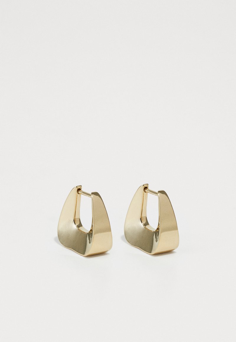 Gold geometric earrings with a polished finish, featuring an abstract shape and prominent cut-out design, secured with a hinge clasp.