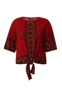 Röd kortärmad topp med knuten framtill, blommönster och kontrasterande mörka kantdetaljer. Tillverkad av ett texturerat, lättviktsmaterial.