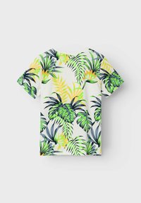 Camiseta de manga corta con un vibrante estampado tropical de hojas de palma verdes y amarillas sobre un fondo crema claro. Material de algodón suave.