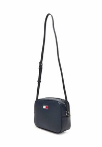 Borsa a tracolla blu navy con superficie in pelle strutturata, forma rettangolare, chiusura con cerniera e un dettaglio con marchio in rosso, bianco e blu.