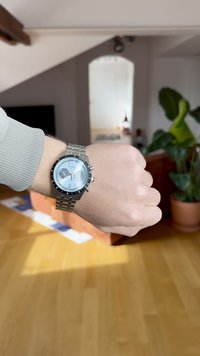 Ceas cronograf argintiu cu brățară din oțel inoxidabil, față rotundă, cadran de culoare bleu deschis, accente negre și afișaj pentru dată la ora 6.