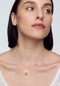 Złoty naszyjnik z łapaczem snów, zdobiony piórkami i detalami z koralików; cienki łańcuszek; dołączony urok w kształcie półksiężyca; delikatny, minimalistyczny design.