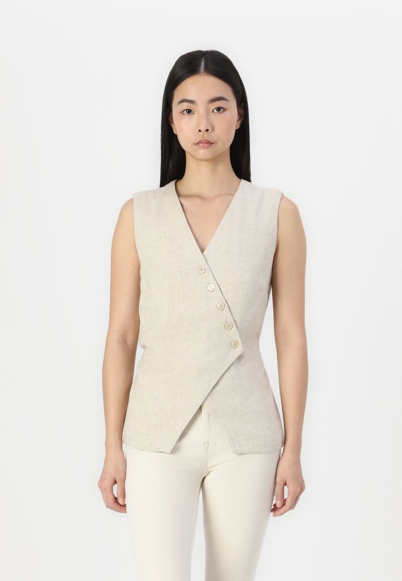 Gilet sans manches en lin beige avec un décolleté en V et un design enveloppant asymétrique, doté de cinq boutons à l'avant. Texture lisse, coupe ajustée.