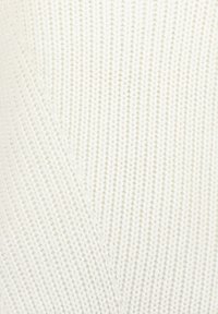 Tessuto bianco lavorato a maglia con un motivo testurizzato, caratterizzato da linee diagonali e piccole cuciture uniformemente distanziate, che creano un aspetto morbido.