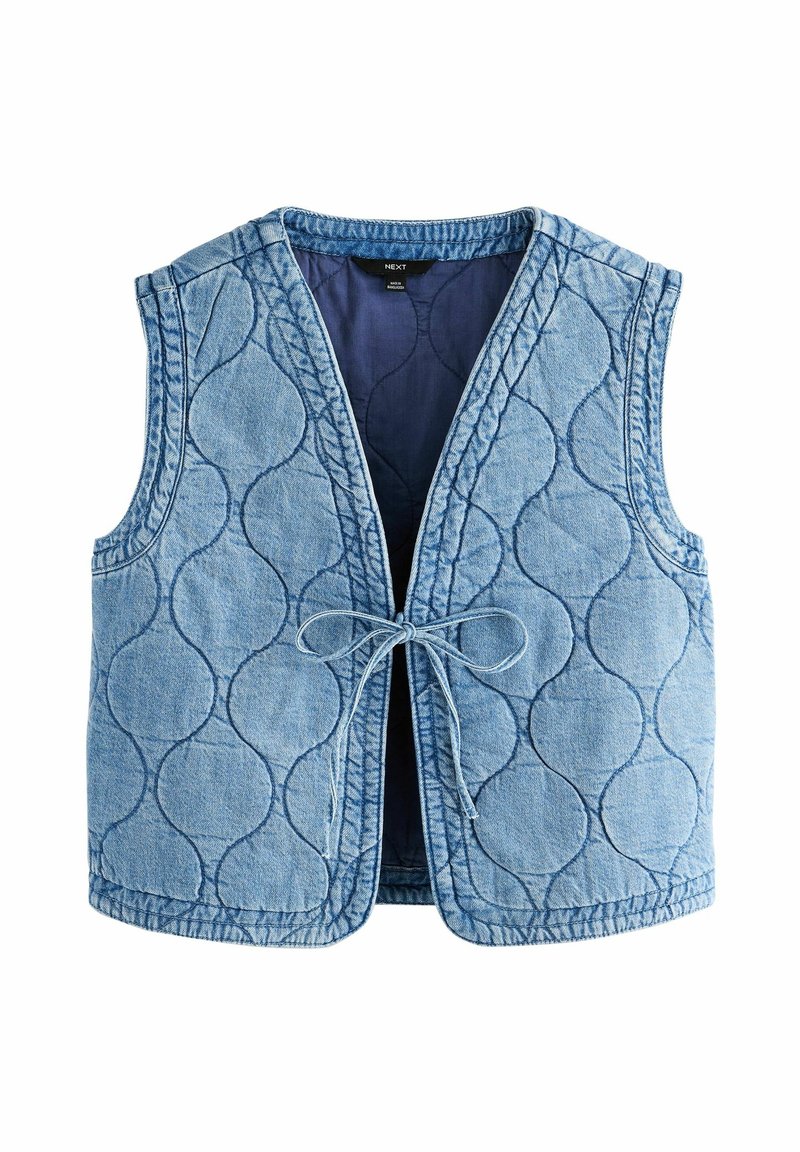 Veste en denim matelassée bleu clair avec de grands motifs circulaires cousus et fermeture nouée à l’avant.