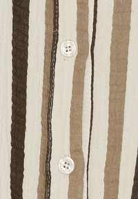 Stribet skjorte i beige, brun og hvid. Fremstillet af letvægtsstof med tekstureret finish, der har to hvide knapper og kontrasterende syninger.