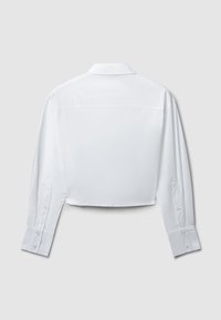 Camicia bianca tagliata con maniche lunghe, polsini abbottonati e colletto classico. Tessuto liscio e leggero con un design pulito.