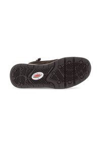 Black rubber shoe outsole with textured tread pattern, featuring circular and geometric designs, and a circular logo inset in red and white.