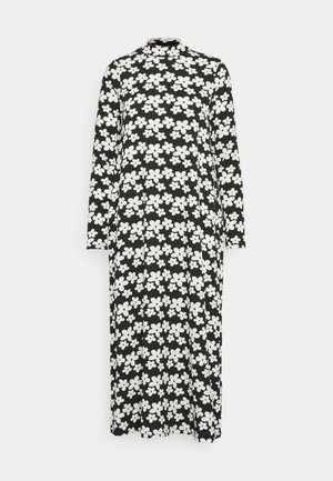 Robe midi noire à manches longues avec motif floral abstrait blanc et col montant, présentée sur fond blanc uni.