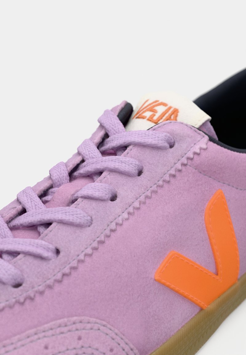 Baskets en suède violettes avec logo orange, bout rond et lacets plats. Possède une semelle texturée contrastante et un col de cheville rembourré.