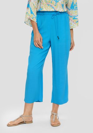 Heldere blauwe, lichtgewicht, cropped broeken met een elastische tailleband en drawstring. Soepele textuur, gecombineerd met zilveren platte sandalen.