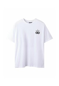 Vit bomull t-shirt med rund hals och korta ärmar. Har en svart grafisk bild av två körsbär med korsade pinnar på vänster bröst.