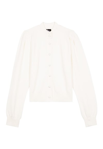 Cardigan blanc à manches longues avec épaules bouffantes, poignets côtelés et une rangée de boutons recouverts de tissu sur le devant.
