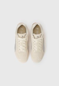Sneaker beige chiaro con accenti grigi, materiali in suede e rete, punta tonda, lacci piatti e piccolo logo di lato e sulla linguetta.