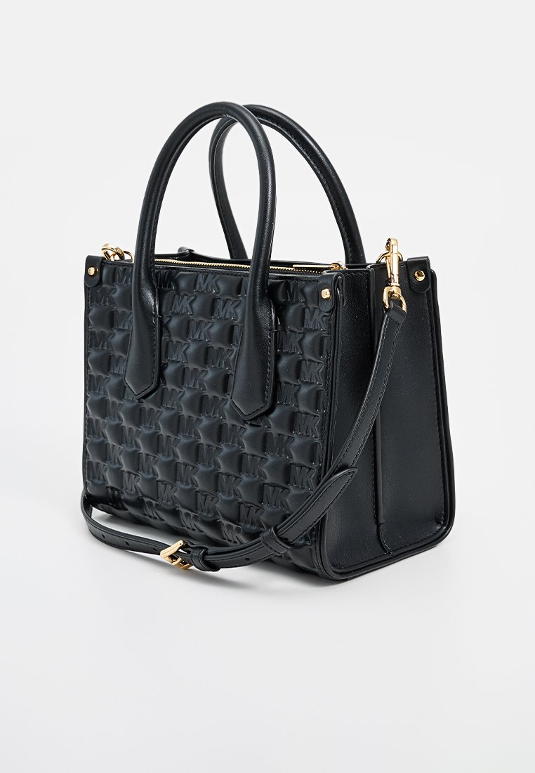 Sac en cuir noir avec un motif texturé présentant les lettres "MK". Deux poignées supérieures et une bandoulière réglable ; accents en métal doré.