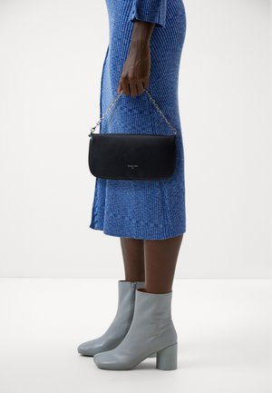Black leather clutch with silver chain strap, smooth texture, rectangular shape. Paired with light blue ankle boots and a ribbed blue dress.