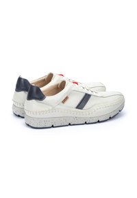Sneakers bianchi in pelle con accenti blu navy, pannelli in rete testurizzati, dettagli rossi a contrasto e una suola in gomma maculata. Dettagli cuciti lungo i bordi.