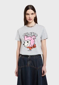 Camiseta de algodón gris con un gráfico de un oso rosa con un lazo rojo, escote redondo y mangas cortas, combinada con una falda de mezclilla oscura.