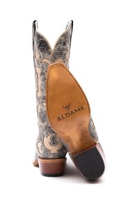 Stivali da cowboy con una parte superiore grigia texturizzata e ricami floreali bianchi, punta appuntita e tacco in legno con un logo sulla suola.