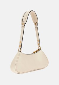 Kremowa skórzana torebka o zaokrąglonym kształcie, z czarną kontrastową lamówką i złotym okuciem. Posiada górny zamek błyskawiczny i regulowany pasek.