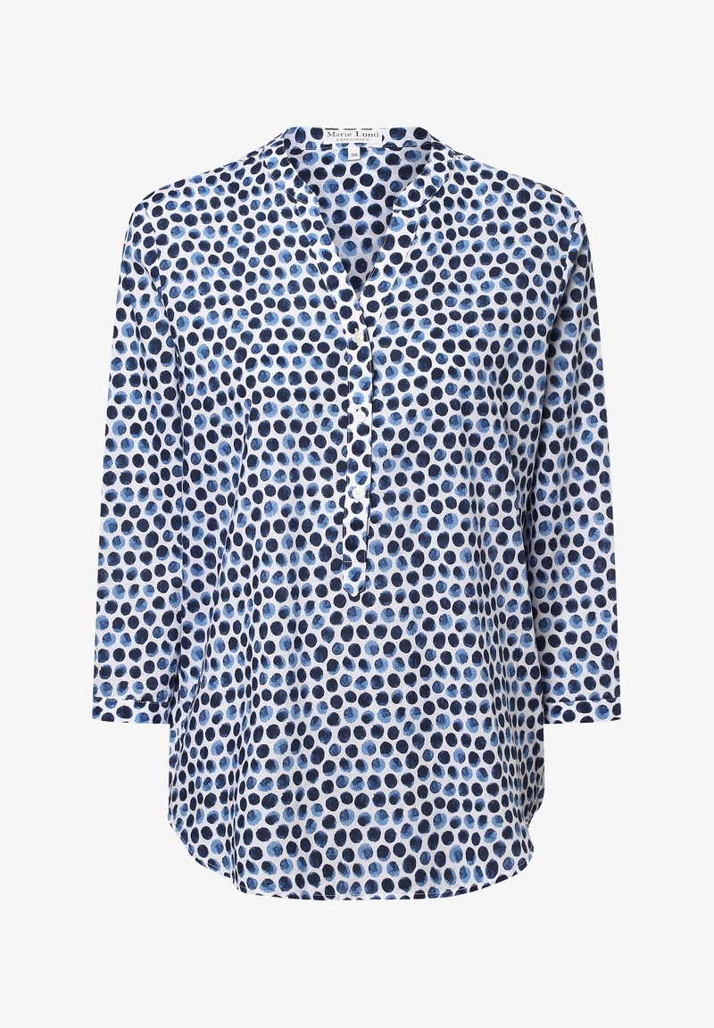 Blouse à manches longues avec encolure ronde, patte de boutonnage, et motif de petits pois circulaires bleu marine et bleu clair sur tissu blanc.