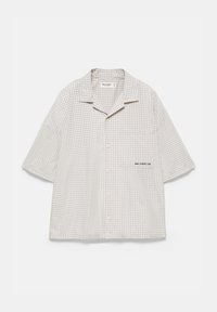 Chemise à manches courtes avec un petit motif à carreaux beige clair et blanc et une poche poitrine avec un texte brodé en noir.