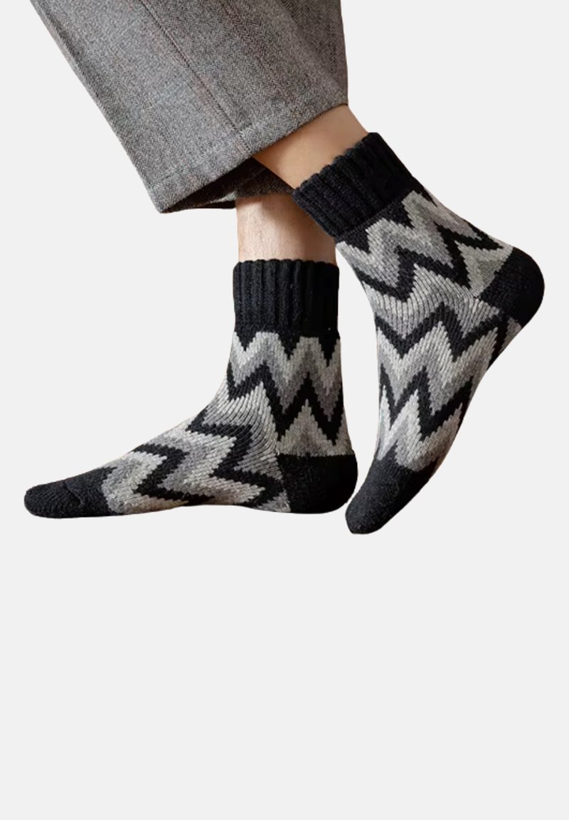 Zigzag-gestrickte Socken in Schwarz, Grau und Creme. Hergestellt aus gestricktem Material mit einem gerippten schwarzen Bund. Knöchellanges Design.