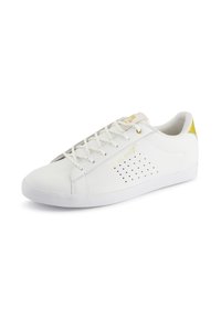 Scarpe da ginnastica bianche realizzate in pelle liscia con dettagli laterali perforati e una suola bianca texturizzata. Presentano accenti dorati sulla linguetta e sul tallone.