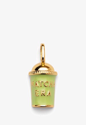 Gold-tone charm shaped like a matcha cup. Green enamel surface with raised letters "MATCHA ERA." Glossy finish and decorative lid.
