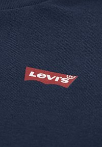 Μπλε ναυτικό T-shirt από βαμβάκι, με κόκκινο λογότυπο Levi's σε κεντημένη κορδέλα με λευκά γράμματα. Το ύφασμα έχει λεπτή υφή με ριμπ λεπτομέρεια.