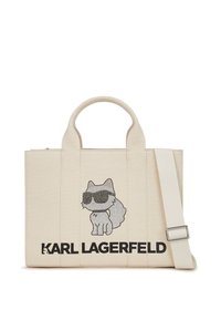 Sac fourre-tout en toile de couleur crème avec un chat gris texturé portant des lunettes de soleil, affichant le logo noir "KARL LAGERFELD" en bas et une bandoulière réglable.