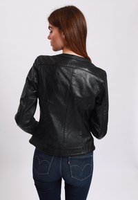 Black leather jacket with a fitted design, smooth texture, and structured shoulder seams. Features a rounded collar and back yoke detail.