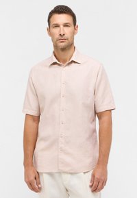 Lichtroze shirt met korte mouwen en een knoopsluitkraag, gemaakt van linnen. Heeft een rechte zoom en subtiele textuur. De knopen zijn crèmekleurig.