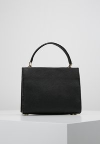 Borsa a mano nera strutturata con finitura testurizzata, dotata di manico corto e dettagli in metallo color oro. Forma quadrata con linee pulite.