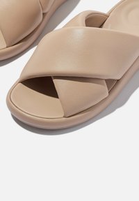Beige schuifsandalen met een kruisbandontwerp, gemaakt van glad synthetisch leer, met een ronde neus en een gevoerd zool.