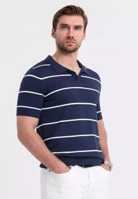 Pruhovaná polo tričko se námořnickou látkou s bílými horizontálními pruhy, krátkými rukávy, límcem a žebrovanými manžetami a lemem.