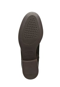 Svart lädersula med texturerad sula och cirkulära perforeringar, med "GEOX ITALIAN PATENT"-märkning nära hälen.