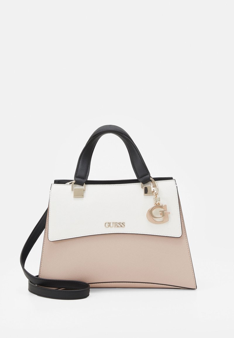 Sac à main Guess bicolore beige et blanc avec poignées noires, bandoulière amovible noire et breloque dorée "G" sur le rabat avant.