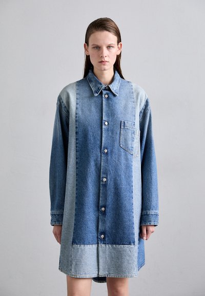 Denim krekls kleita ar pogu priekšā, kurai ir gaiši un tumši zili toņi, kabata kreisajā pusē un garas piedurknes.