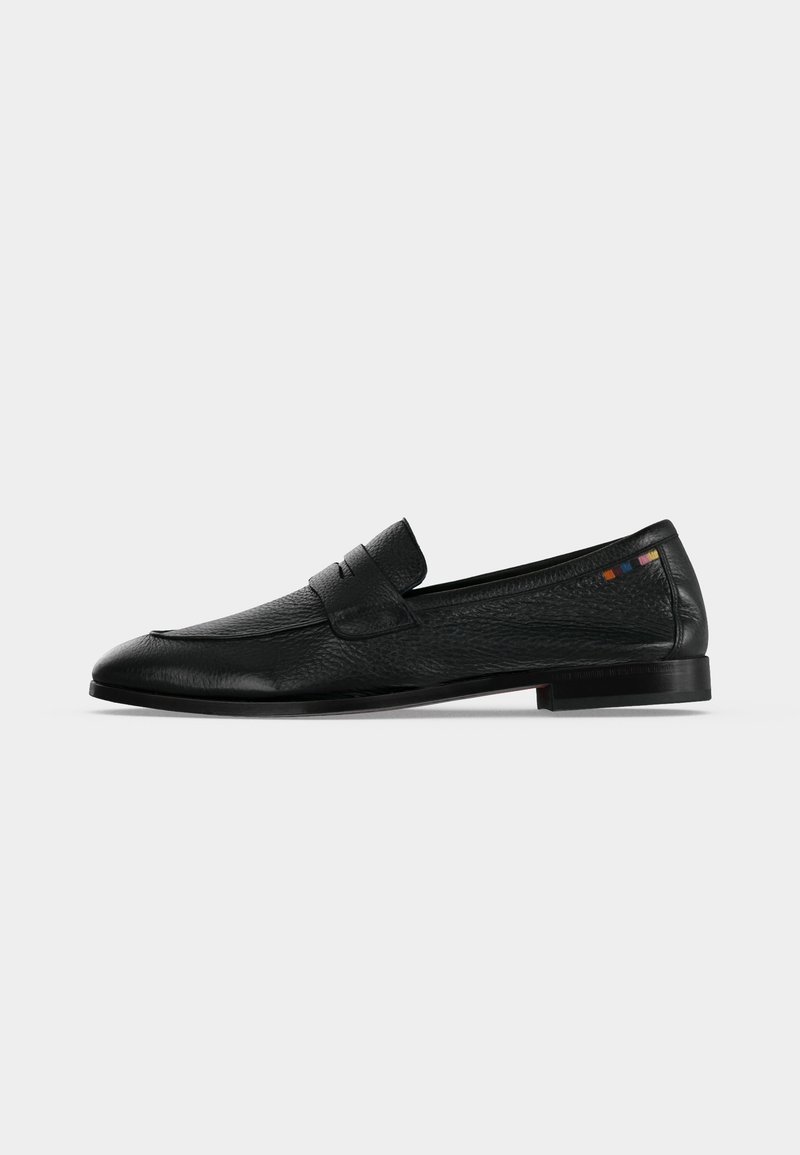 Mocassin penny en cuir noir avec petit talon, surface texturée et petite couture carrée multicolore près du talon sur fond blanc.