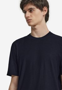 Marinblå kortärmad t-shirt, rund halsringning, mjukt tyg, avslappnad passform, med en enkel och ren design. Inga synliga mönster eller detaljer.