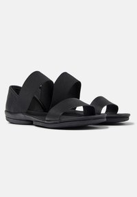Svarta sandaler med breda elastiska remmar, öppen tå, texturerade sulor och vadderade innersulor för komfort och flexibilitet.