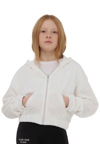 Felpa bianca con zip, dal taglio rilassato, con tasche frontali, polsini e orlo elastici. Materiale morbido, caratterizzato da un design minimalista senza pattern.