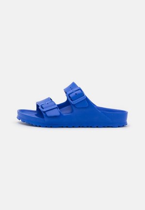 Blaue Gummisandale mit zwei verstellbaren Riemen mit Schnallen, einer konturierten Fußbettung und einer strukturierten Außensohle für besseren Halt.