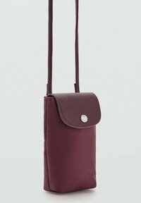 Borsa a tracolla borgogna con un flap in pelle textured e una chiusura a scatto in argento. Forma rettangolare con corpo in tessuto morbido e tracolla regolabile.